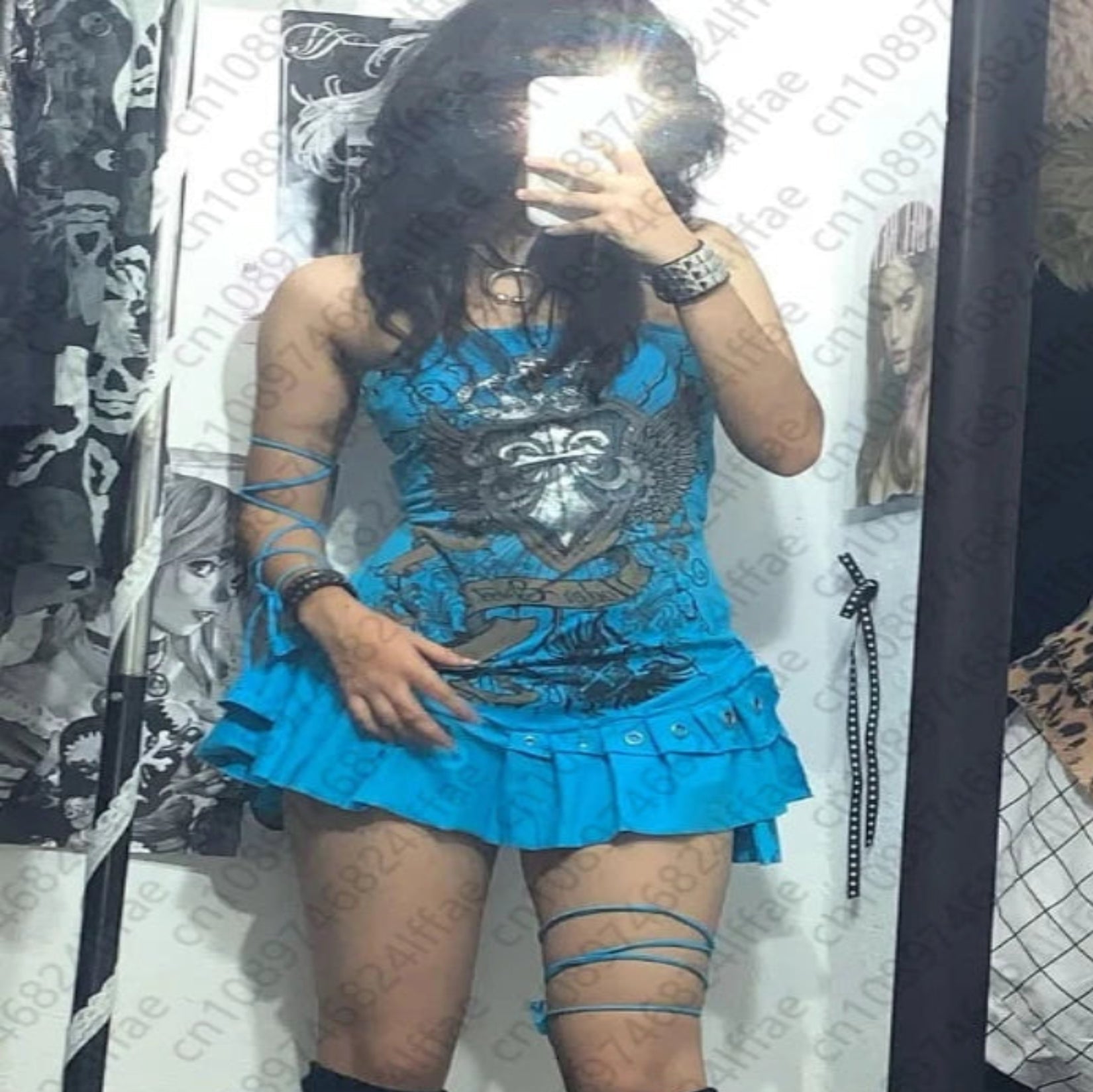 Person wearing a blue dress with ruffles, black knee-high socks, and white furry boots in a room.